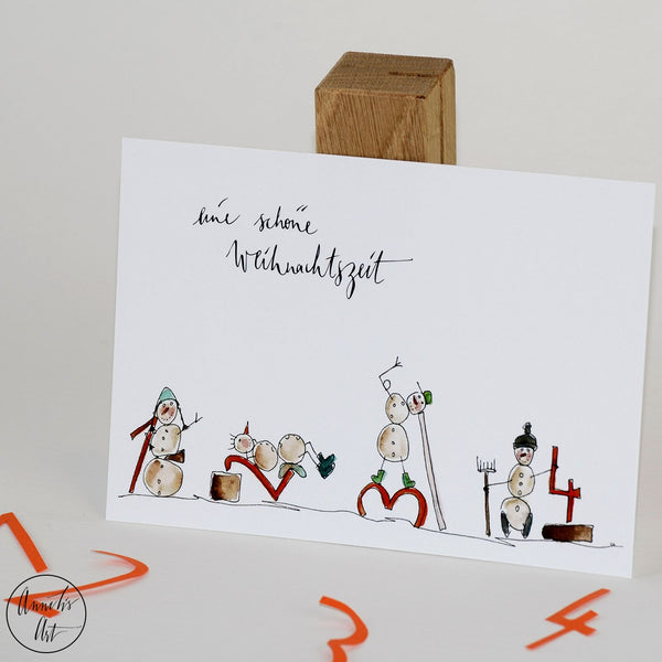 Aufgestellte Postkarte mit Weihnachtsmännern von Annelis Art mit Spruch "Eine schöne Weihnachtszeit"