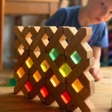 1. Kind baut mit Bauspiel X-Klötzen und bunten Lichtbauwürfeln
