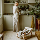Charlie Crane Babywippe LEVO im Mimosa Design in Küche stehend
