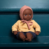 Puppe Mimosa der POMEA-Kollektion von Djeco auf Bank sitzend