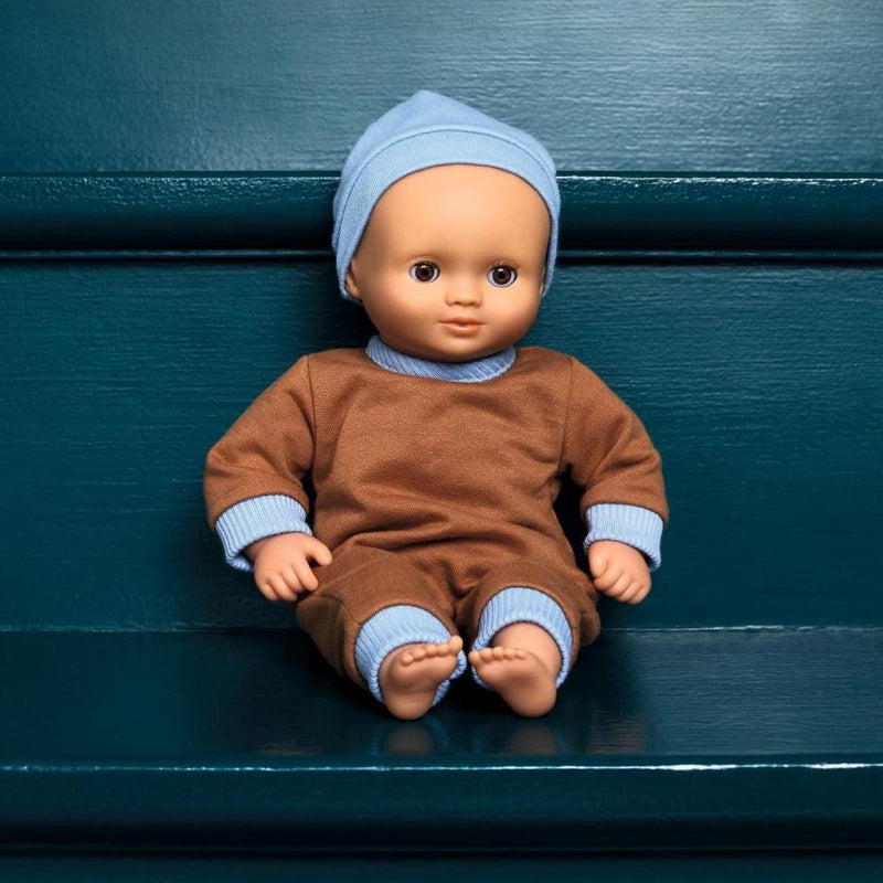 Puppe Baby Praline der POMEA-Kollektion von Djeco auf Bank sitzend