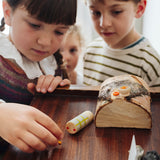 Kinder spielen gemeinsam mit kleinen Holzteilen aus dem Grapat Adventskalender 2026