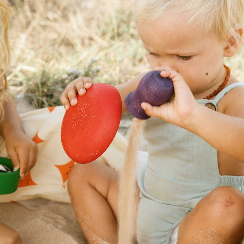 Kind spielt mit bunten Holzgefäßen von Grapat