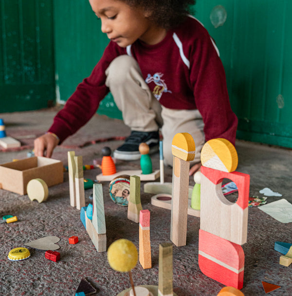 Kind das mit Happy Place Spielset aus 40 Naturholz-Teilen von Grapat spielt