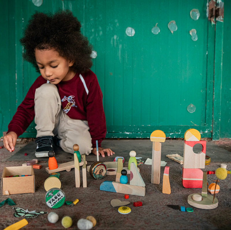 Kind das mit Happy Place Spielset aus 40 Naturholz-Teilen von Grapat spielt