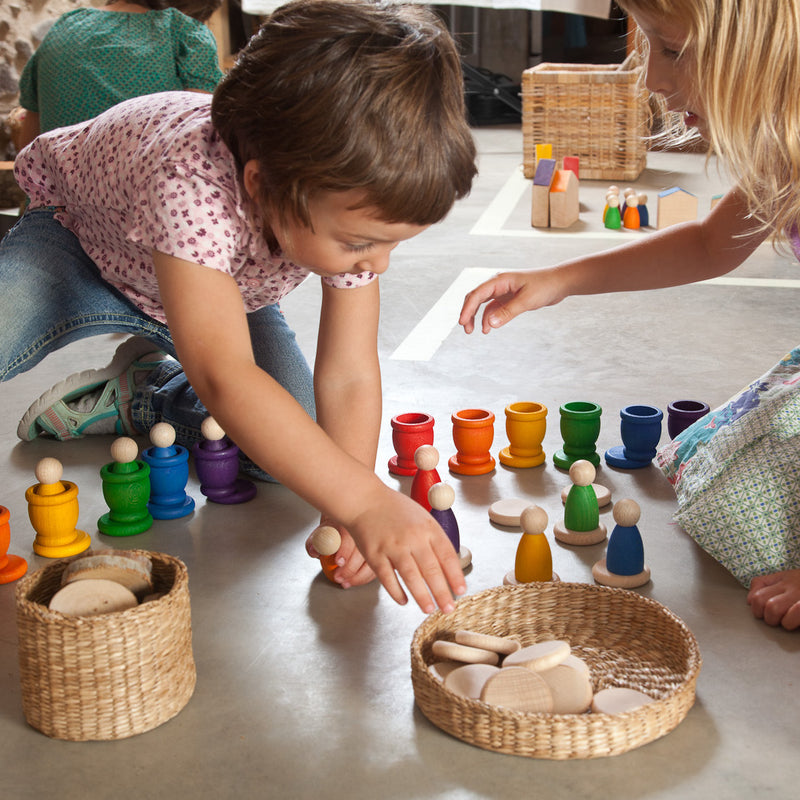 Kinder am Spielen mit 18-teiligem Set aus Nins, Bechern und Münzen von Grapat