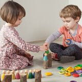 Kinder am Spielen mit 120-teiligem Holz-Spielset Carla von Grapat in Regenbogenfarben
