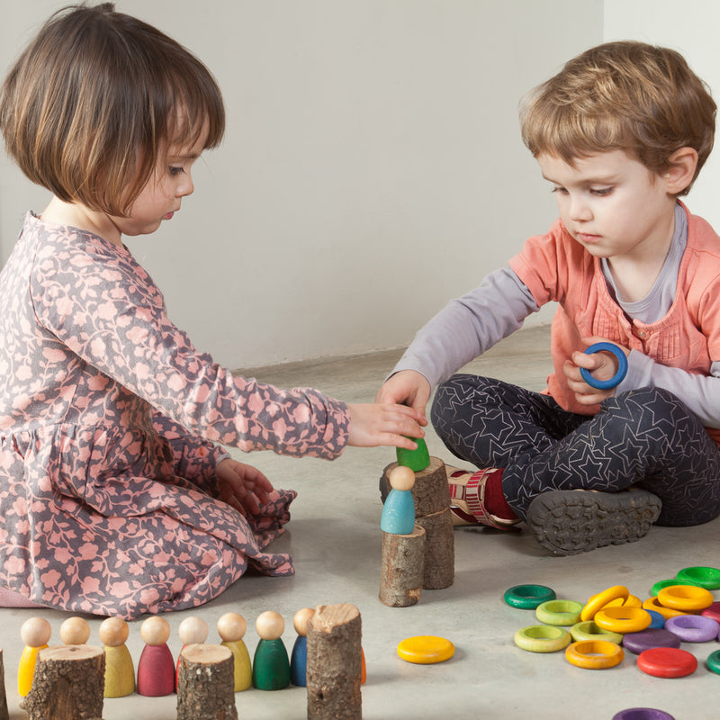 Kinder am Spielen mit 120-teiligem Holz-Spielset Carla von Grapat in Regenbogenfarben