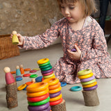 Kind am Spielen mit Nahaufnahme von 120-teiligem Holz-Spielset Carla von Grapat in Regenbogenfarben