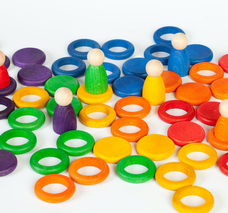 Grapat Spielset aus Nins, Münzen und Ringen in Regenbogenfarben auf Boden verteilt