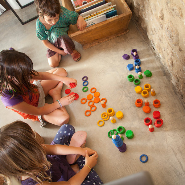 Kinder beim Spielen mit Grapat Spielset aus Nins, Münzen und Ringen in Regenbogenfarben