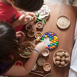 Kinder beim Spielen mit Grapat 6 Schälchen und Holzmurmeln in Regenbogenfarbe
