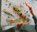 Kind spielt auf Küchentisch mit handbemaltem Holzgemüse "Veggies" von Grapat