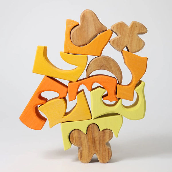 Holzteile von Bauspiel Gelb von Grimm's aufeinandergestapelt