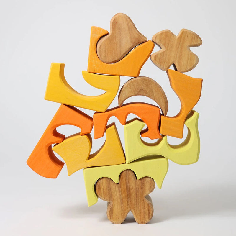 Holzteile von Bauspiel Gelb von Grimm's aufeinandergestapelt