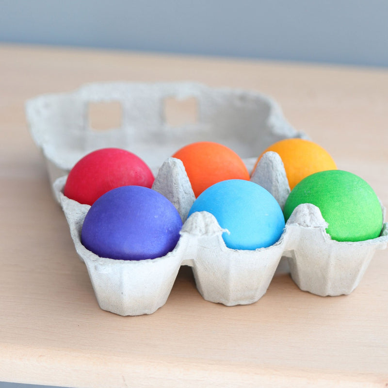 Holzkugeln Regenbogen von Grimm's in Eierverpackung auf Tisch stehend