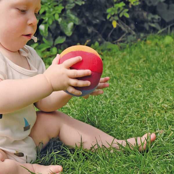 Kind spielt mit Regenbogenball von Grimm's