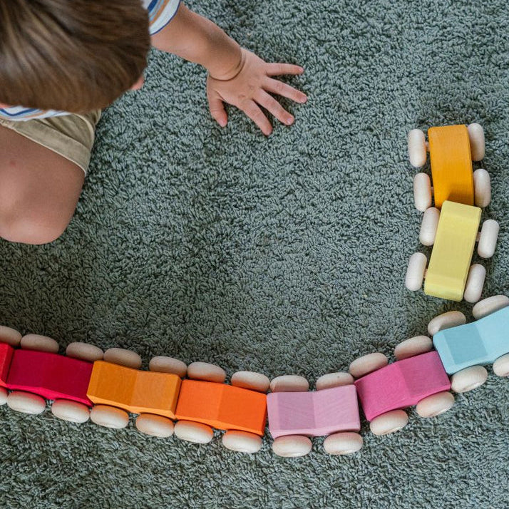 Kind am Spielen mit Stapel-Autos von Grimm's