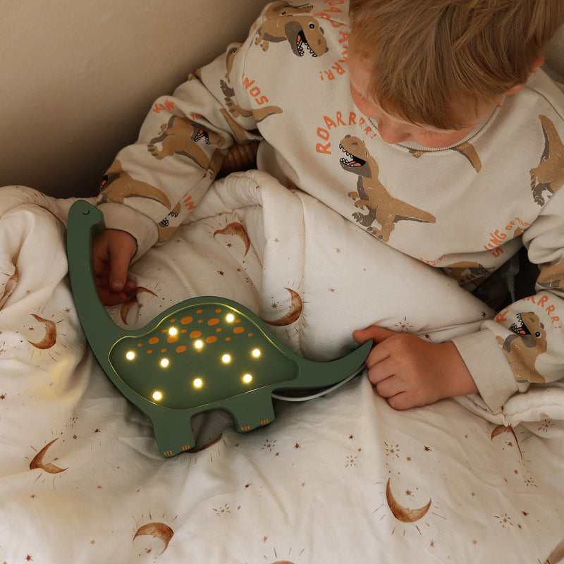 Dino Kinderlampe von Little Lights mit Kind in Bett