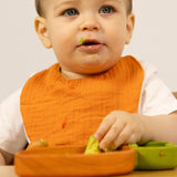 Kind mit Karotten-Lätzchen "Cathy the Carrot" von Oli&Carol