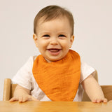 Lachendes Kind mit Karotten-Lätzchen "Cathy the Carrot" von Oli&Carol