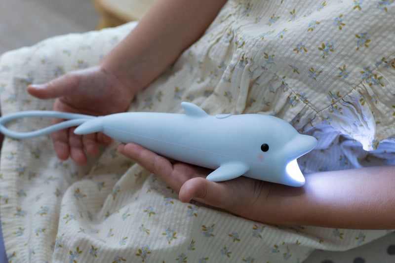 Delfin Kindertaschenlampe von Rabbit & Friends in Händen von Kind