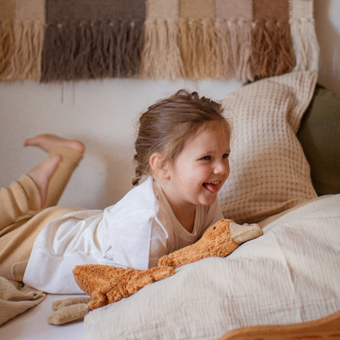 Kind  liegt in Bett mit Kleine Gans von Senger Naturwelt im Farbton Rost