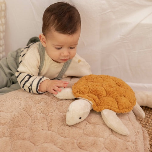 Kind mit Kuscheltier und Wärmekissen Schildkröte im Farbton Messing von Senger-Naturwelt