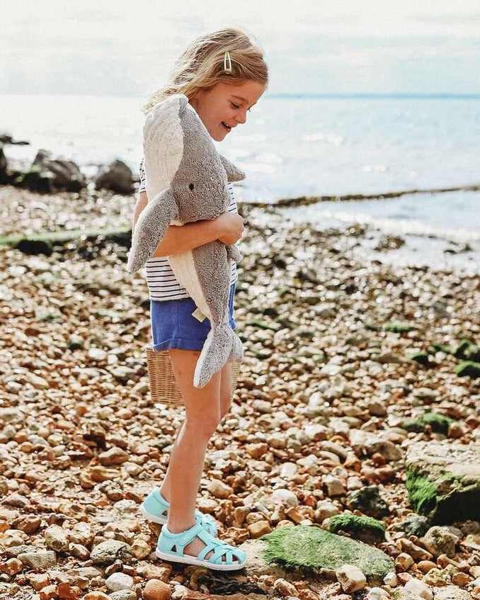 Mädchen am Strand mit großem Wal Kuscheltier und Wärmekissen von Senger Naturwelt