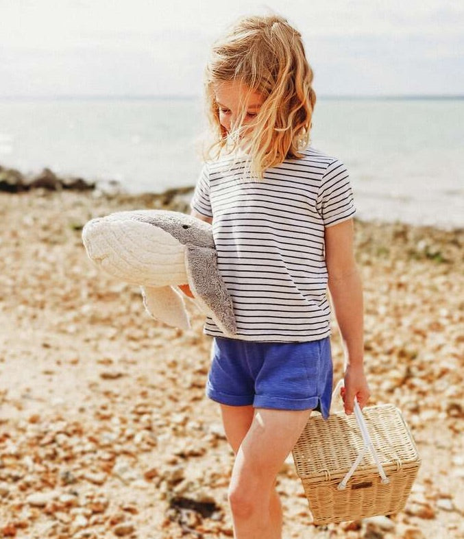 Mädchen am Strand mit großem Wal Kuscheltier und Wärmekissen von Senger Naturwelt