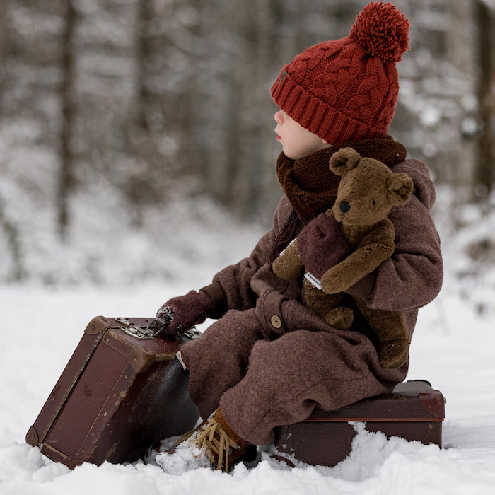 Kind in Schnee mit Brauner Bär Schlenker Kuscheltier von Senger Naturwelt