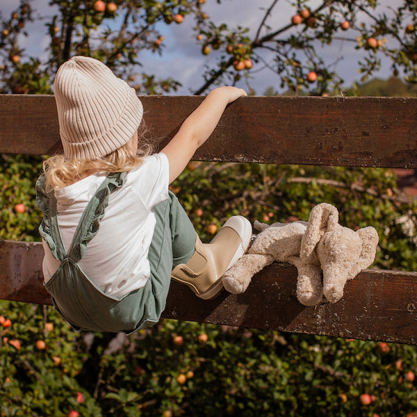 Kind an Zaun mit Kleinem Elefant von Senger Naturwelt im Leinen-Farbton