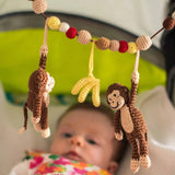 Gehäkelte Kinderwagenkette Affe CHARLIE in Braun von SindiBaba an Kinderwagen angebracht
