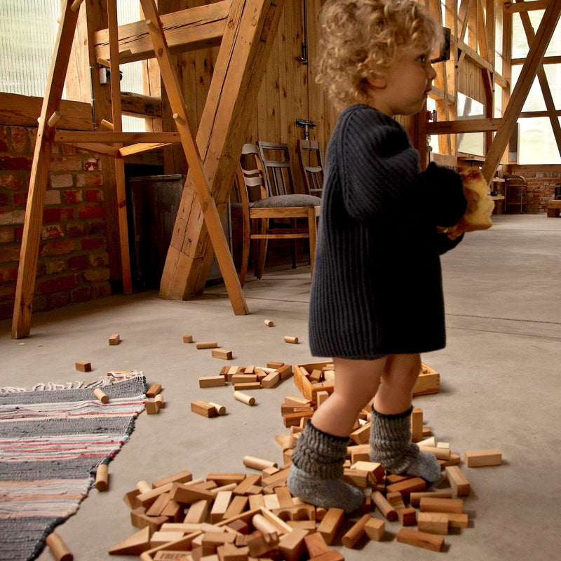 Kind am Spielen mit 100 Bauklötzen aus Naturholz in Naturfarben von Wooden Story