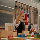 Kind das mit Wooden Story Set mit 63 XL Bauklötzen in Regenbogenfarben spielt