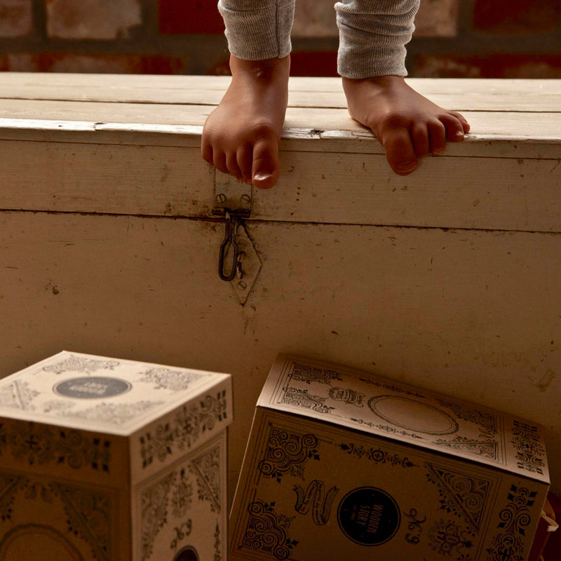 Kinderfüße aus Holzkiste über Verpackungen von Holz Stapelturm von Wooden Story