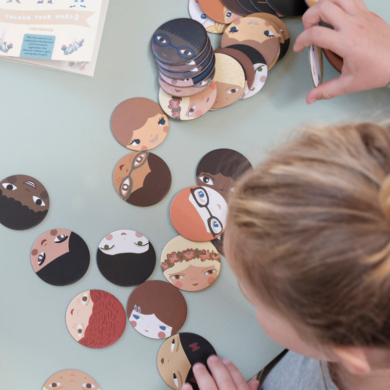 Kind beim Spielen von Memory-Spiel "Let's play together" von Fabelab_mit Gesichter-Karten